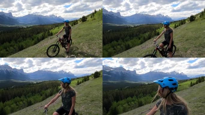 女性山地自行车手在高山草甸停下来，骑自行车