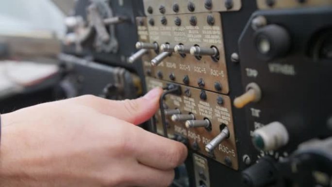 飞行员的手指切换旧飞机驾驶舱中的开关。