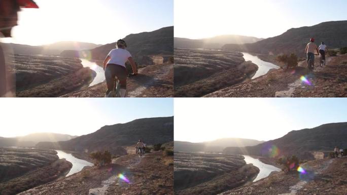 成熟的山地自行车夫妇沿着沙漠小路，经过岩石