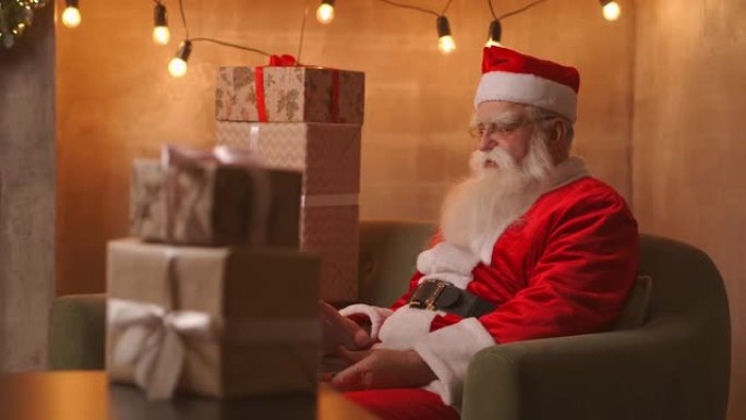圣诞老人视频打电话给笔记本电脑上的孩子，现在坐在家里的桌子上。流行病和圣诞老人的隔离远程祝贺儿童