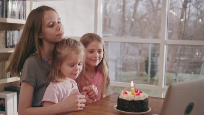 三姐妹庆祝生日。在线视频通话。吹蜡烛，互相拥抱