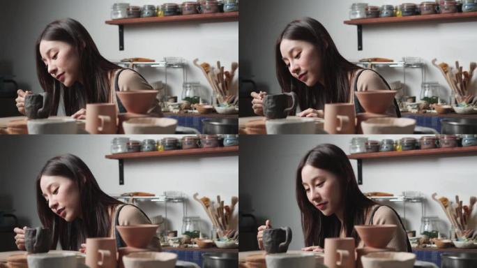 年轻女子在陶器工作室用粘土覆盖和装饰陶瓷。波特女孩在烤粘土上画颜色。教育、商业、艺术天赋和创意手工制