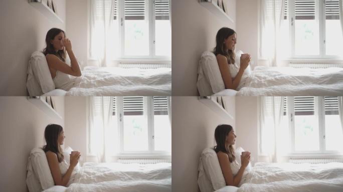 年轻女子在床上喝咖啡