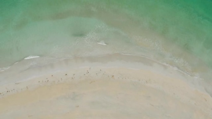 空中无人机在阴天拍摄绿水群山的沙滩