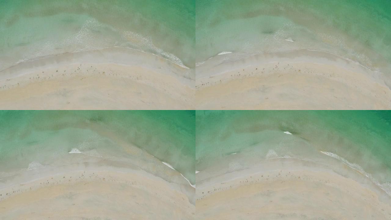 空中无人机在阴天拍摄绿水群山的沙滩