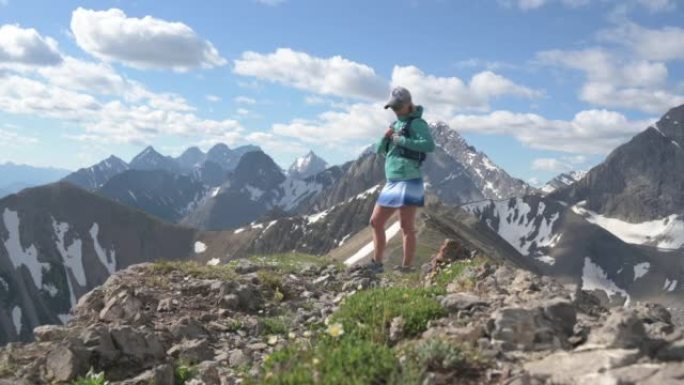 女徒步旅行者和宠物狗在山顶上享受时光