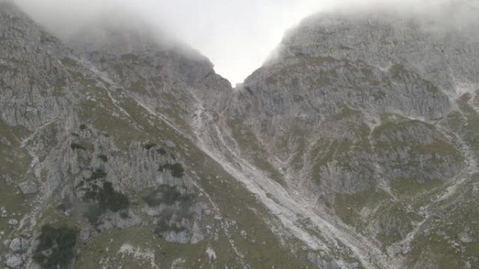 在高耸的山峰和山谷之间飞行的鸟瞰图