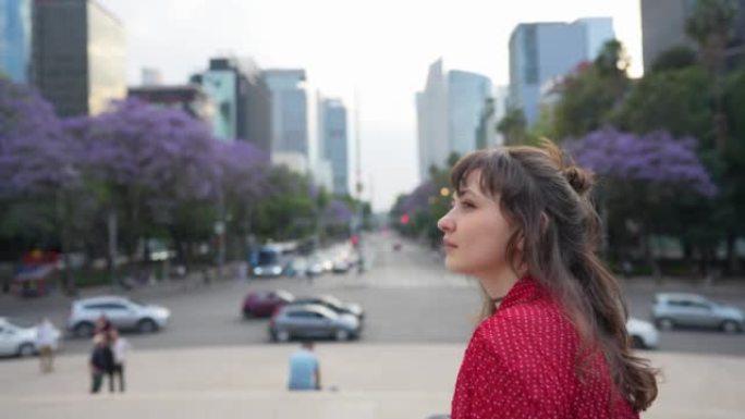 女人坐在城镇广场上看着墨西哥城