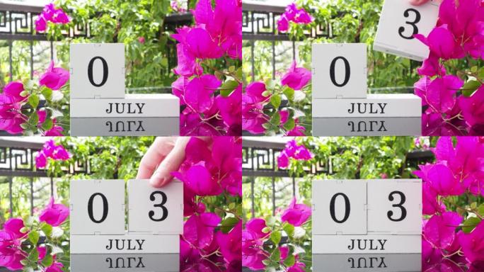 一个木制日历，有一个重要的活动，7月3日在一张有芙蓉花的桌子上，女人的手在日历上设定了日期。将日历翻
