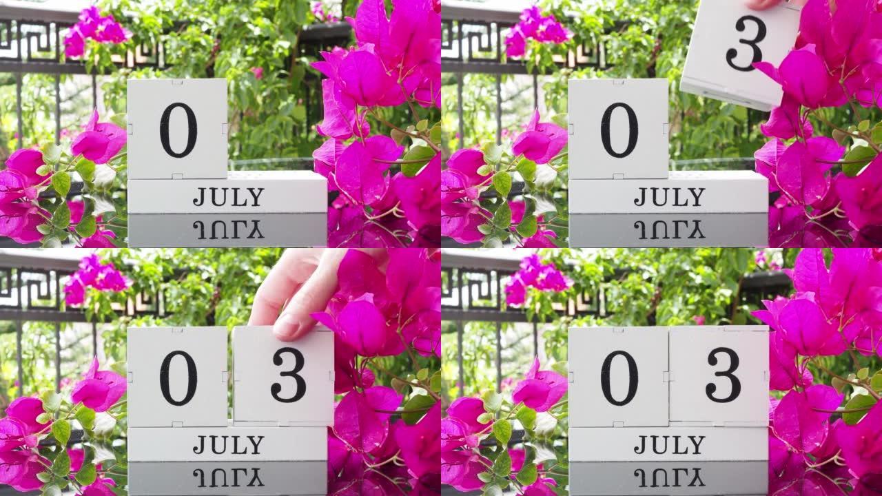 一个木制日历，有一个重要的活动，7月3日在一张有芙蓉花的桌子上，女人的手在日历上设定了日期。将日历翻