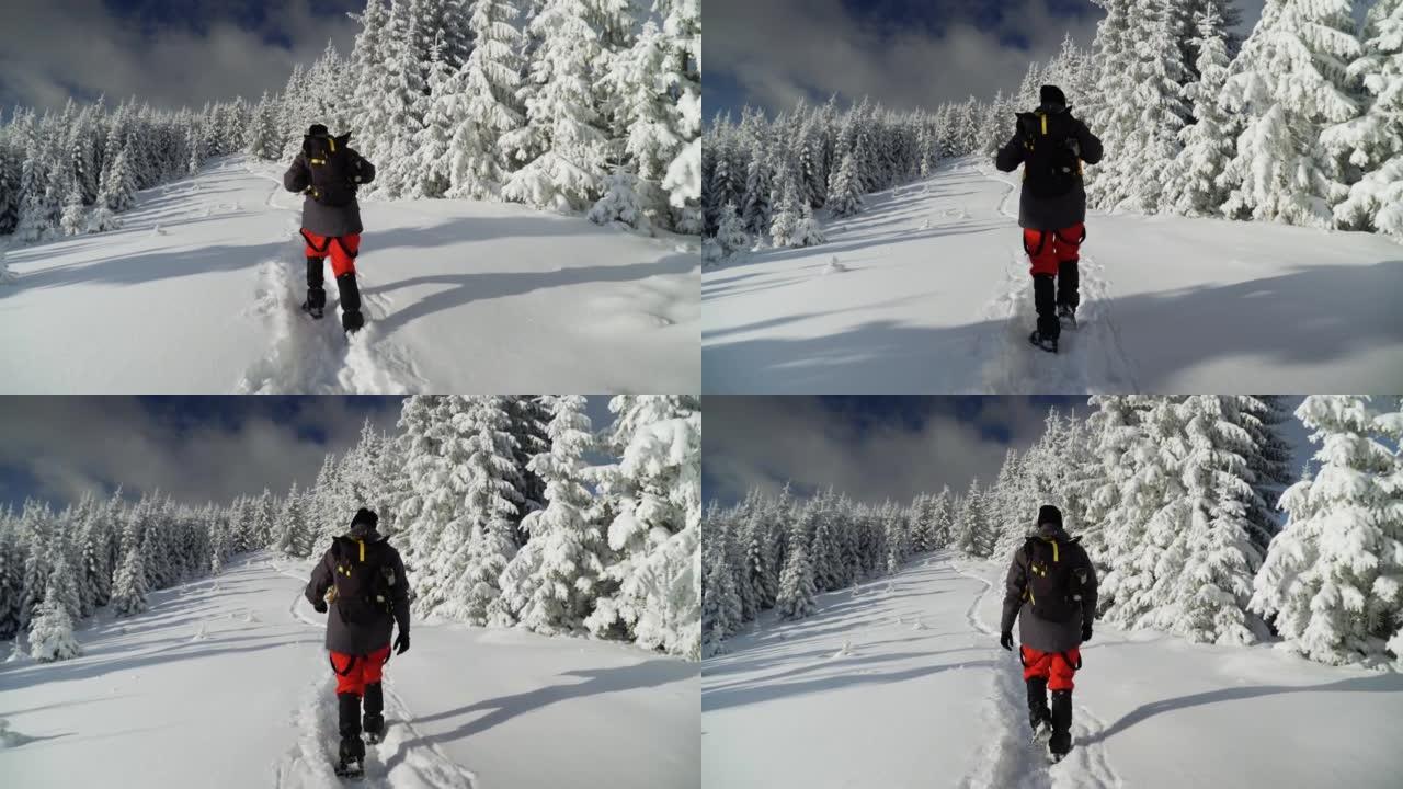 男性徒步旅行者徒步进入冬季山地景观