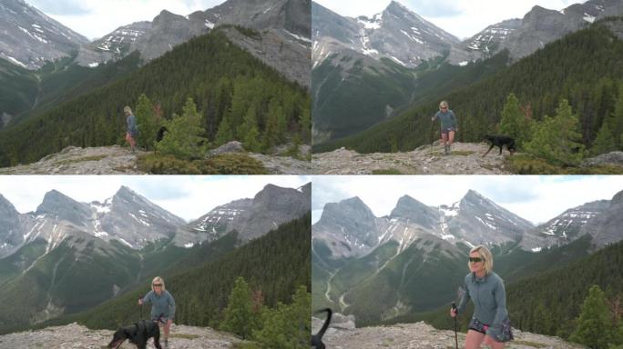女徒步旅行者带着狗到达山脊，远处的山脉