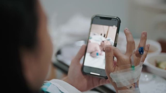 亚洲女性患者躺在医院的病床上看着手机照片。