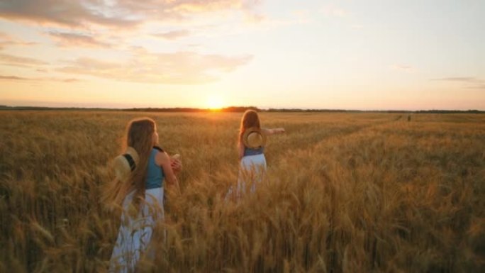 日落时分，两个小农女儿一起走在金色的麦田里，美丽的农业景观