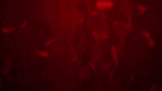 4k背景抽象模糊红色，背景中发生液化。熔化彩色玻璃效果股票视频。缓慢溶解并流下液体抵抗光束。