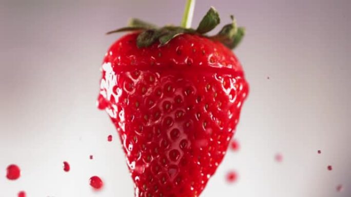 草莓切片掉落并溅到白色背景上。食物悬浮概念。慢动作