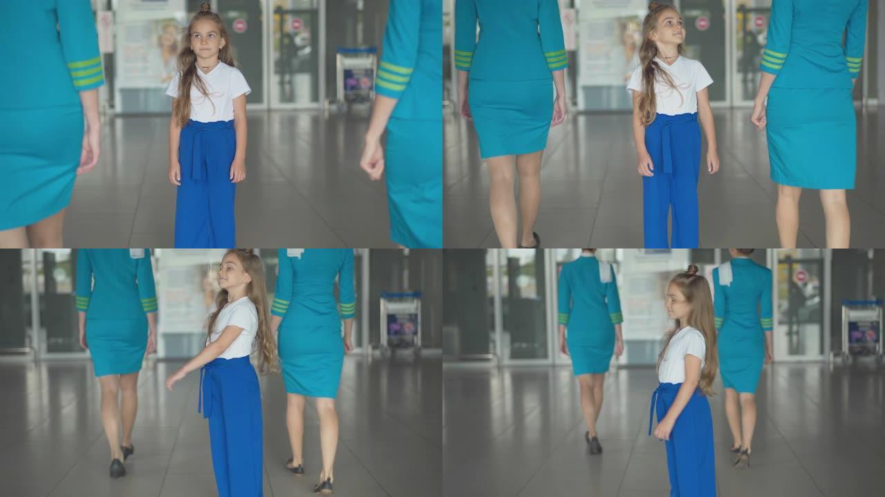 漂亮的高加索小女孩欣赏空姐进入机场，看着相机。可爱的孩子喜欢等待出国的肖像。梦想成为空姐。