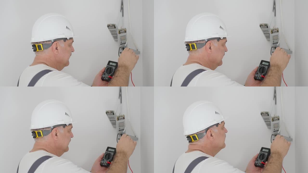 男性电工在智能家居系统中安装用于照明的变压器。安装检查照明