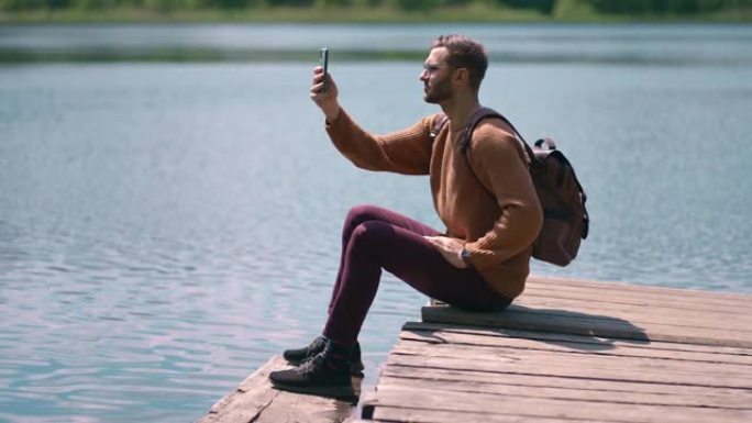 勇敢的人在森林湖里拍照，用智能手机拍摄风景自然背景，享受度假旅行冒险。慢动作