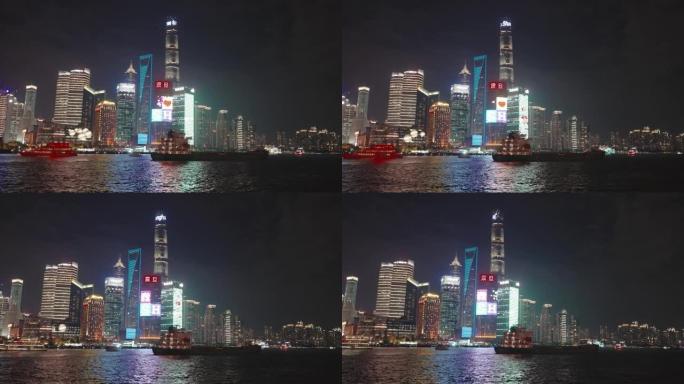 晚上在黄浦江上运行的船的镜头，中国上海。