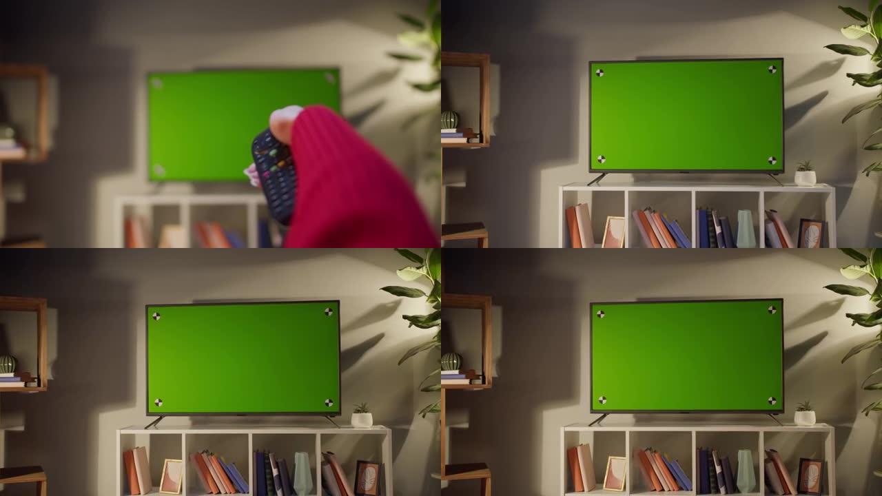 用色度绿屏看电视的女人。无法识别的女性用遥控器在电视上切换频道，坐在客厅的沙发上。业余时间在家，放松