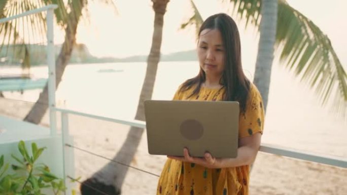 在泰国苏梅岛旅行时在笔记本电脑上工作的亚洲妇女。