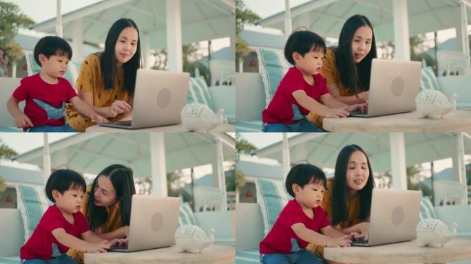 亚洲母亲和她的儿子 (2-3岁) 在笔记本电脑上工作