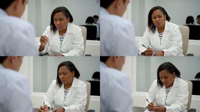 黑人女精神病医生在病历上做笔记时采访患者