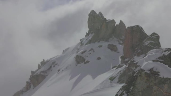 在阴天，滑雪者在山上攀登的远摄照片