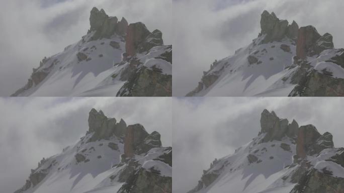 在阴天，滑雪者在山上攀登的远摄照片