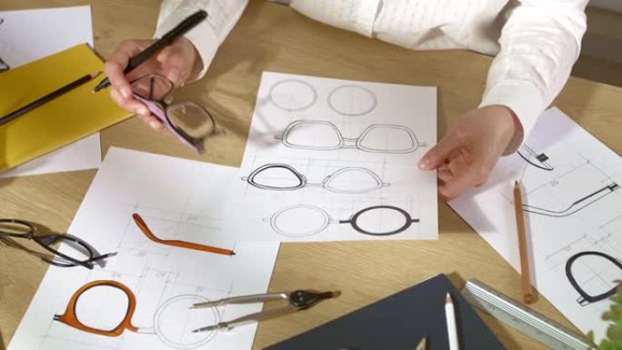 设计师根据眼镜图纸的纸质草图进行开发。