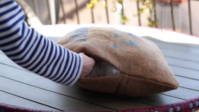 双手将柔软的填充物放入带有乌克兰刺绣的粗麻布坐垫中