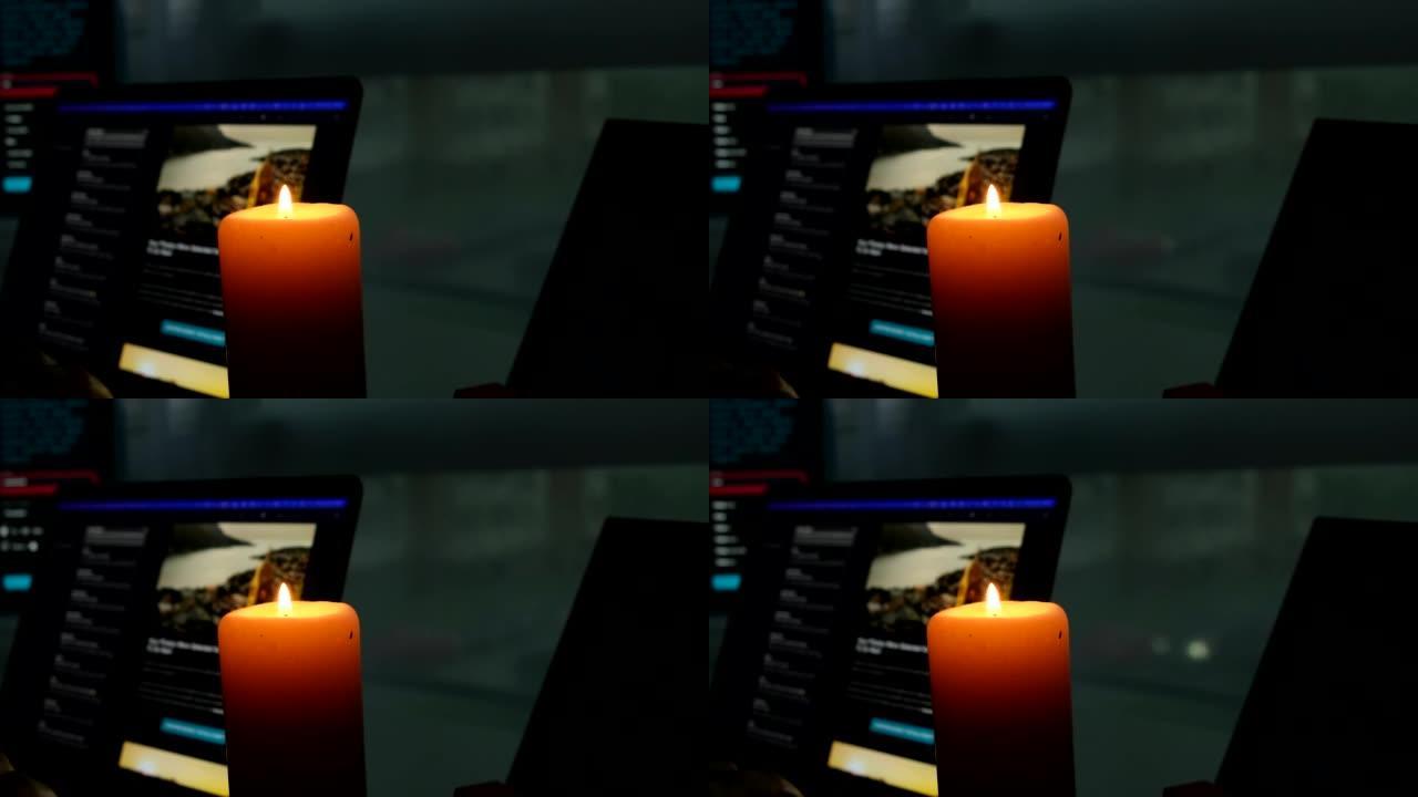 蜡烛灯特写背景上的笔记本电脑显示器