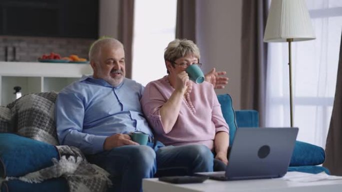 老年已婚夫妇通过在线视频聊天与朋友或孩子交流，退休人员坐在一起在家