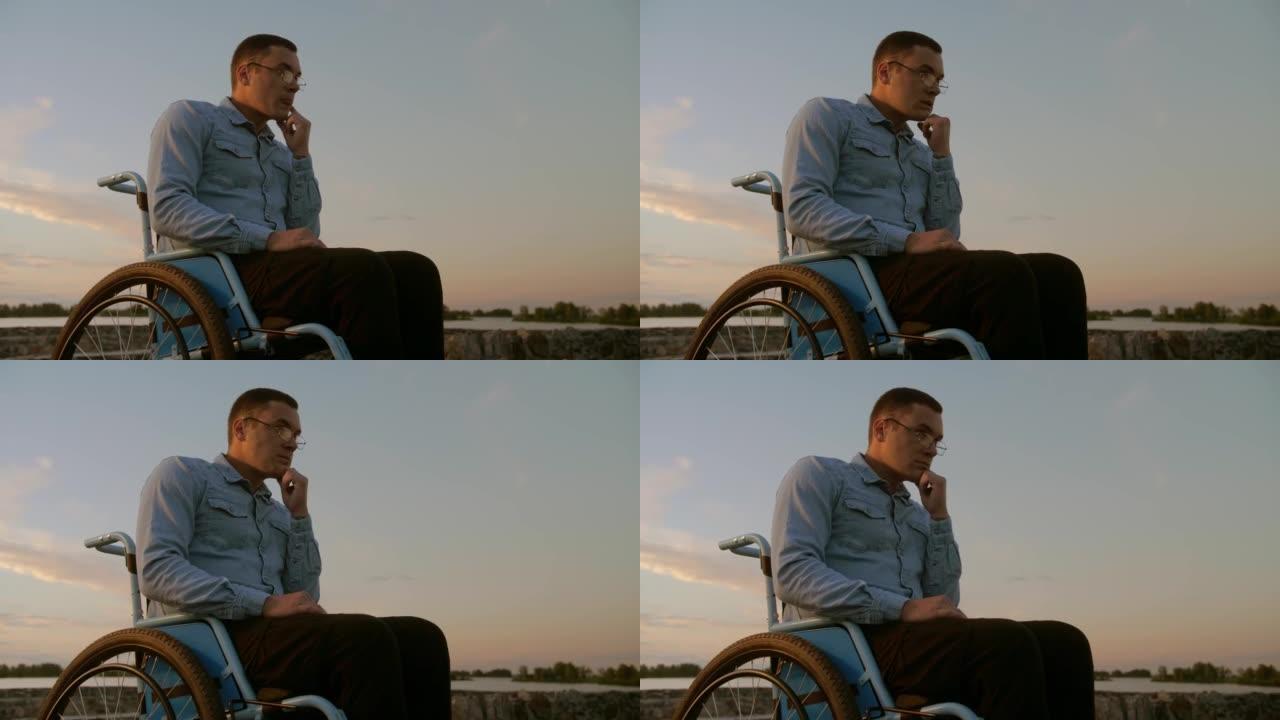 坐在轮椅上戴着眼镜的人望着远方，希望康复。戴眼镜的残疾小伙子想离开轮椅，正常生活。。