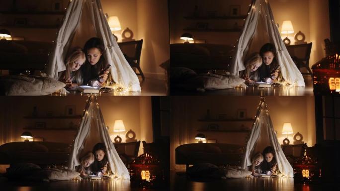 一个年轻的西班牙裔母女俩拿着手电筒在家里的帐篷里看书，上面装饰着房子的黑暗，神奇的装饰。母女舒适的氛