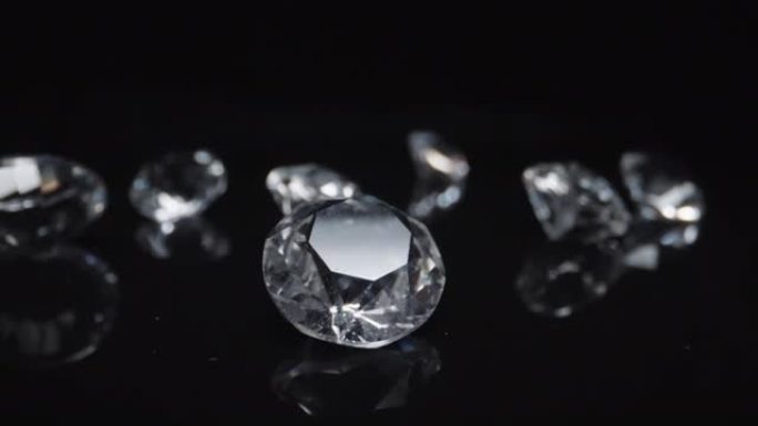 一组圆形经典形状钻石镶嵌在深色反光表面背景