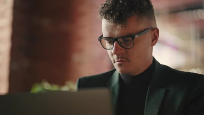 年轻聪明的西班牙裔商人员工戴着眼镜，在办公室上网工作。公司经理穿着时髦西装的英俊中年男子在午休时间在