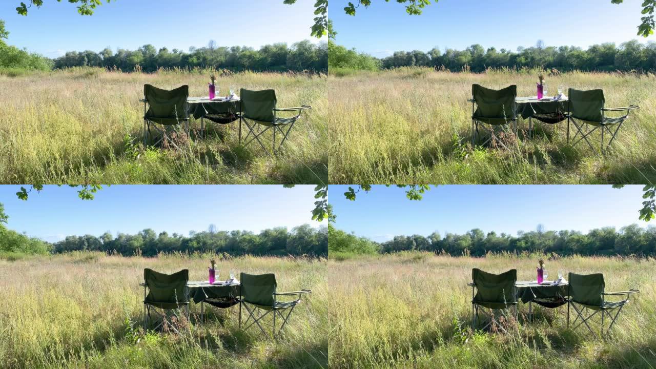 露营椅和夏天野餐的桌子。野餐餐饮。