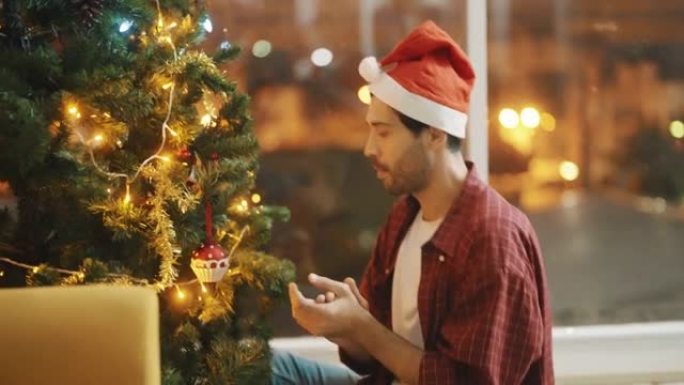 男人装饰圣诞树并在夜晚庆祝