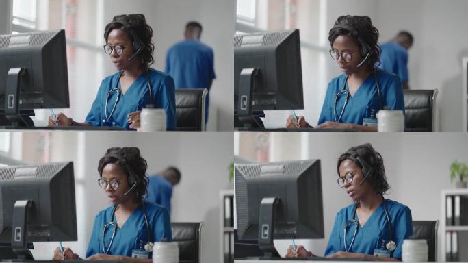 非洲女医疗助理穿着白大褂，耳机视频在电脑上给远方病人打电话。医生使用虚拟聊天计算机应用程序与客户交谈
