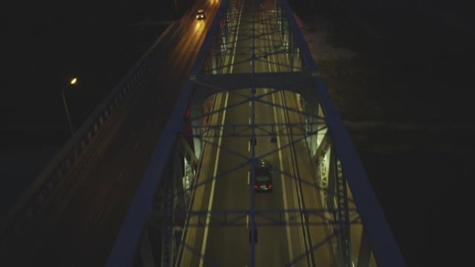 科宁瓦尔塔河上大桥的鸟瞰图。夜间照明双车道道路和行驶中的汽车