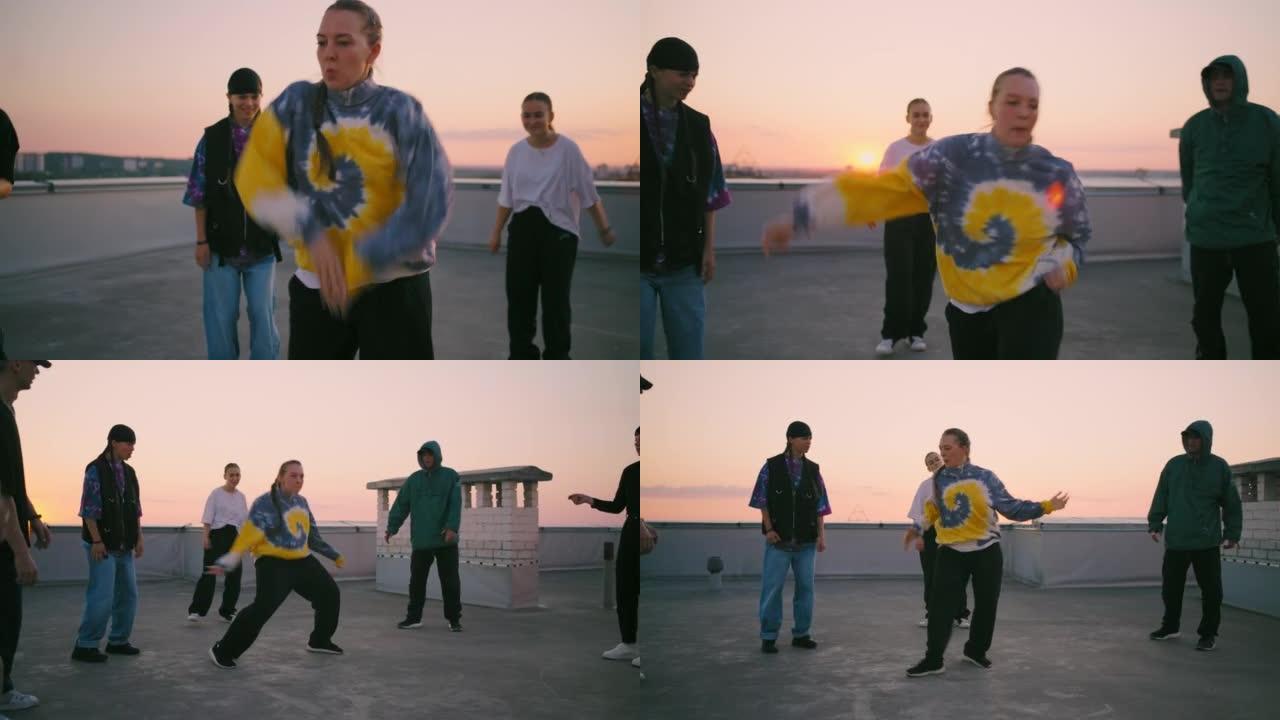 一群年轻的舞者在日落时的城市屋顶上玩得开心，嘻哈表演者一起跳舞