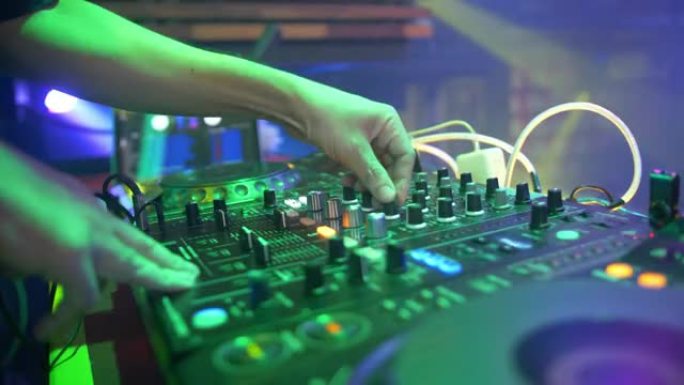 DJ在夜总会使用混音控制台