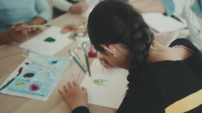 快乐的小学生和她的朋友一起上绘画课。