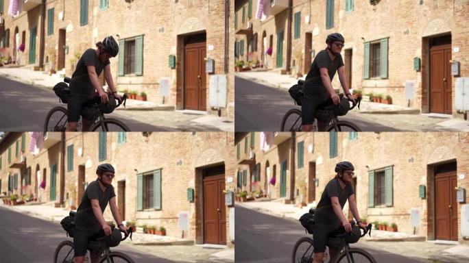 骑自行车的人停下来欣赏中世纪小镇的风景