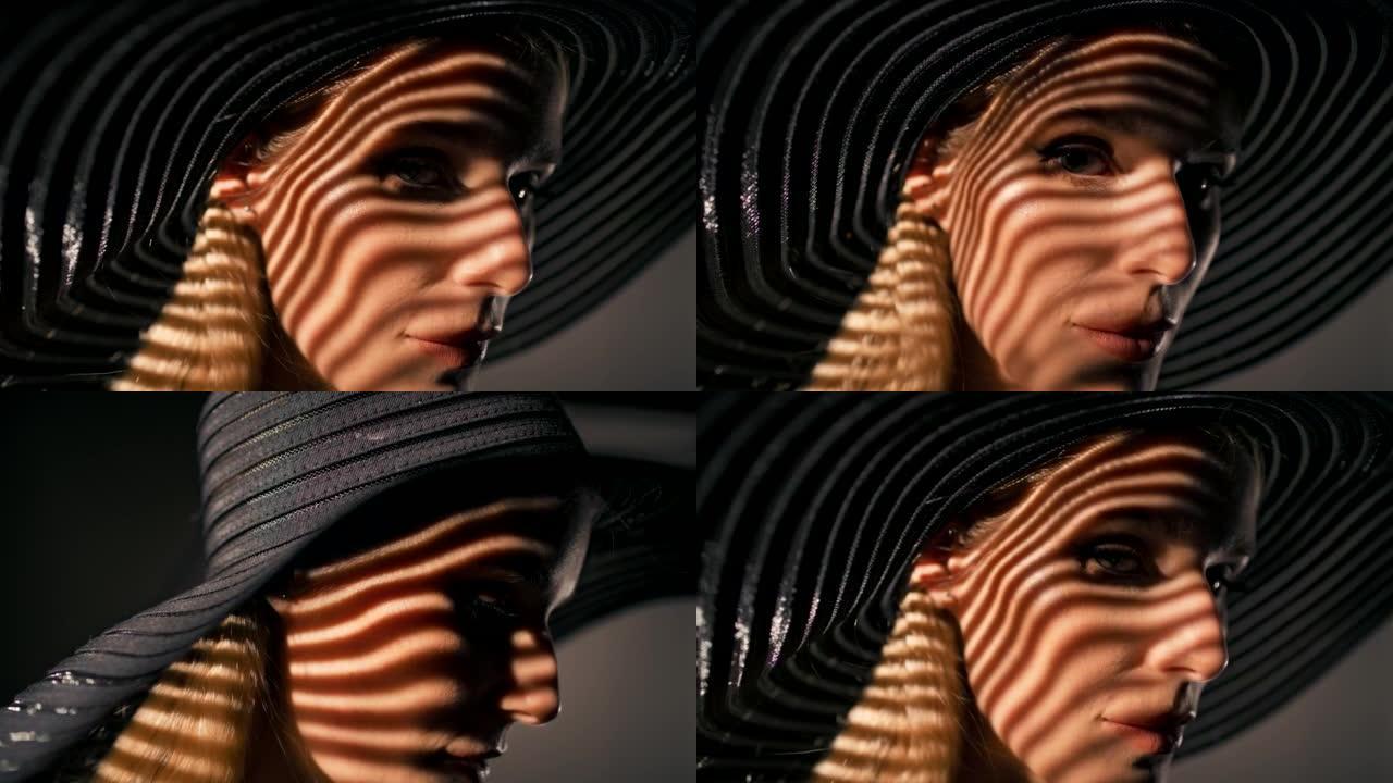 美丽诱人的金发女人用相机调情。戴着大而优雅的帽子摆姿势，遮住她的脸