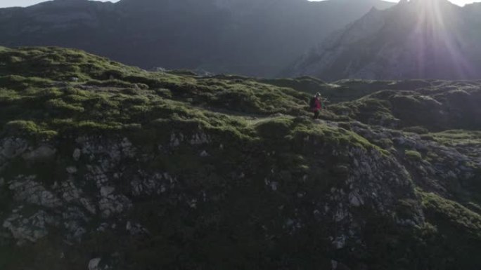 空中无人机拍摄的一名年轻女子在山区崎terrain的地形中徒步旅行