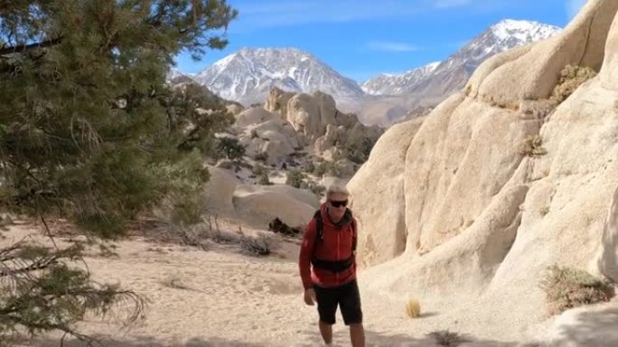 男性徒步旅行者通过岩石登上沙漠通道