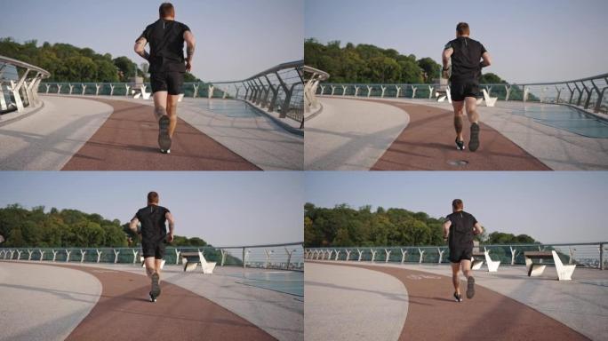 男子用玻璃围栏在人行天桥的红色跑道上奔跑